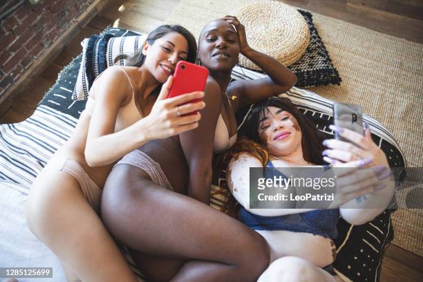 three women with different bodies and skin posing in lingerie - three people in bed stock pictures, royalty-free photos & images