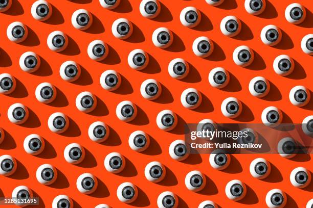 repeated eyes on the red background - rhythm stock-fotos und bilder