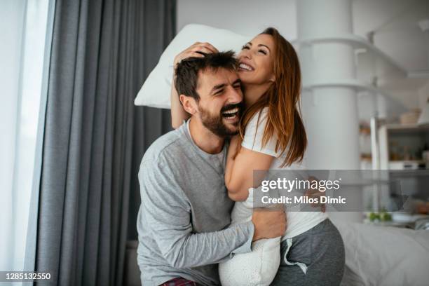 paar mit einem spaß beim kissen kampf stock foto - kissenschlacht paar stock-fotos und bilder