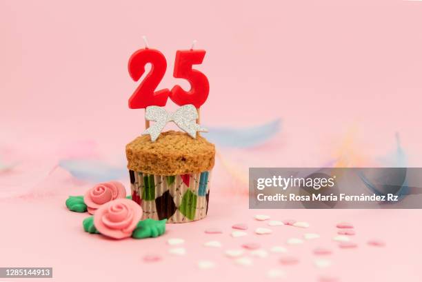 number 25: cupcake with a numbered birthday candle on pink background. - number 25 stock-fotos und bilder