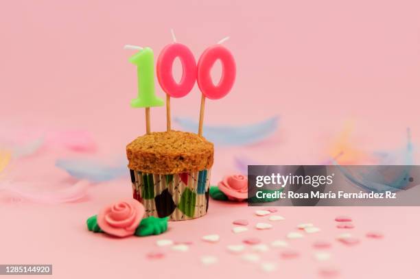 number 100: cupcake with a numbered birthday candle on pink background. - 100 birthday stock pictures, royalty-free photos & images