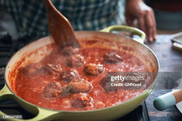 het bereiden van gehaktballen met tomatensaus in een pan - gehaktbal stockfoto's en -beelden