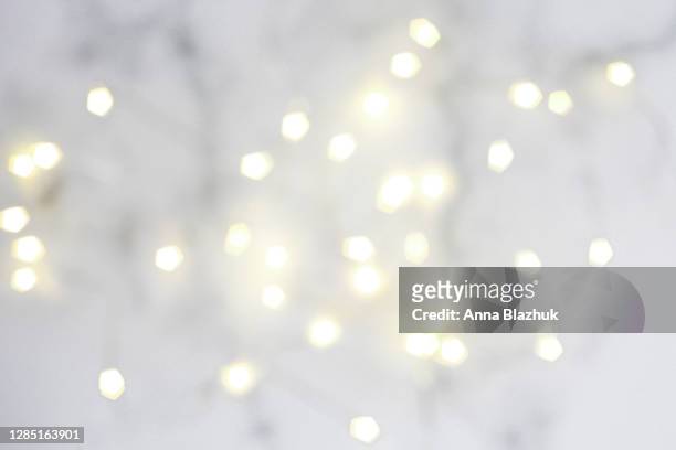 blurred fairy lights, festive white abstract background for christmas or new year greeting card - cadena de luces fotografías e imágenes de stock