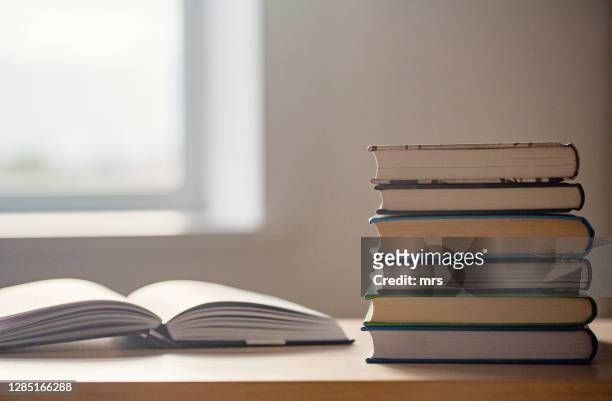 stack of books on table - boek stockfoto's en -beelden