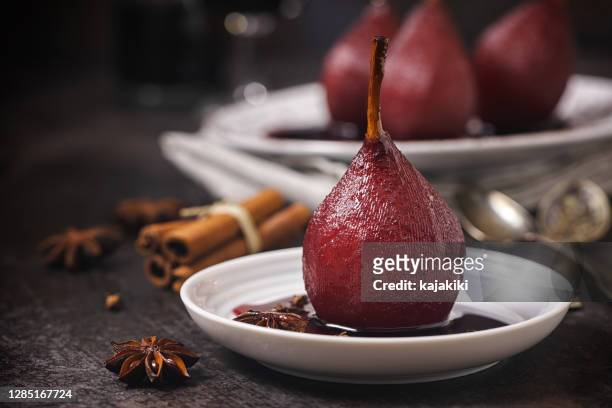 pochierte birnen in rotwein für die feiertage - pear stock-fotos und bilder