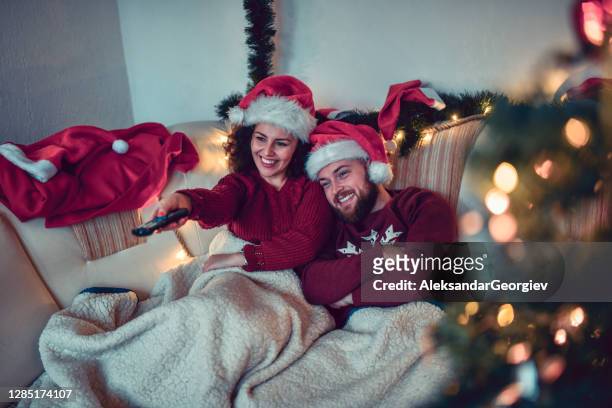 linda pareja disfrutando de la navidad con tv y película bajo las mantas - lovers 2020 film fotografías e imágenes de stock
