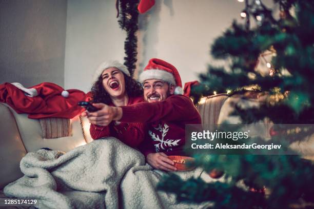 paar dat een film op de vooravond van kerstmis in bed bekijkt - movie and tv fotos stockfoto's en -beelden