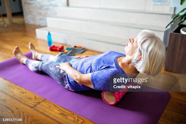 foam roller massage for lower back pain - back stretch stock pictures, royalty-free photos & images