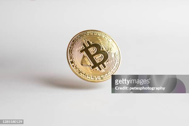a gold bitcoin floating above a white background - bitcoin stock pictures, royalty-free photos & images