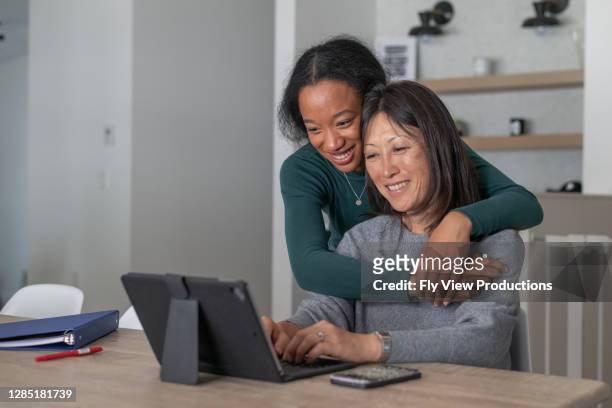 mother and teenage daughter use video chat to visit with family and friends - college visit stock pictures, royalty-free photos & images
