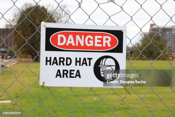 hard hat requirement sign outside of a construction site - chain fence stock-fotos und bilder