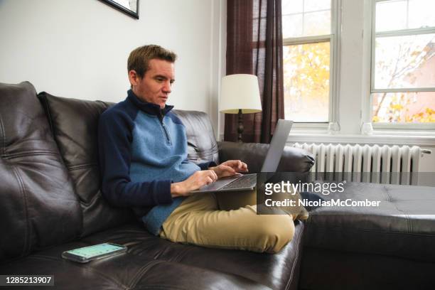 mature man working at home on his laptop - autism adult stock pictures, royalty-free photos & images