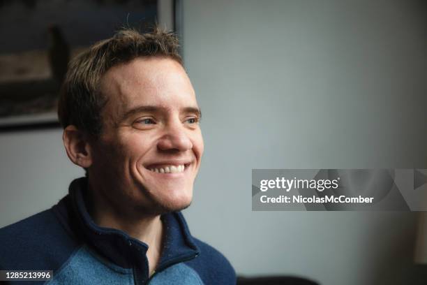 close-up of a mature autistic man at home smiling as he looks away - developmental disability stock pictures, royalty-free photos & images