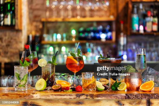 assortment of alcoholic cocktails on a bar counter - bar counter stock pictures, royalty-free photos & images