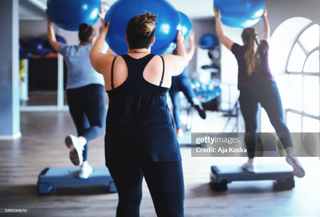 Mujeres con sobrepeso haciendo ejercicio juntas en el gimnasio
