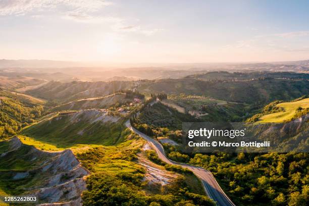 volterra cliffs (balze) at sunset. aerial view - volterra stock-fotos und bilder