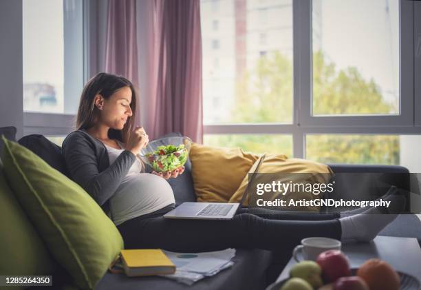 pregnant woman eating healthy food and using technology. - pregnancy healthy eating stock pictures, royalty-free photos & images