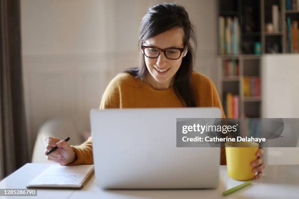 a woman working from home - télétravail photos et images de collection