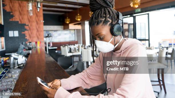 african woman using her phone with covid19 mask - windhoek stock pictures, royalty-free photos & images