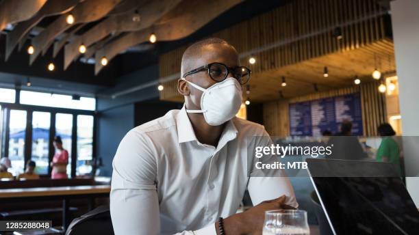 african businessman in a restaurant with covid19 mask - windhoek stock pictures, royalty-free photos & images