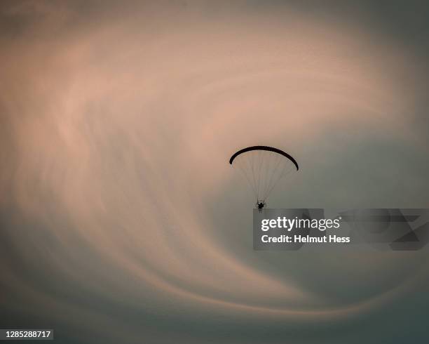 paraglider pilots against a dramatic sky - glider stock pictures, royalty-free photos & images