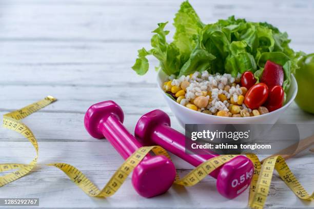 workout and fitness dieting copy space diary. healthy lifestyle concept. dumbbell, vegetable salad and measuring tape on rustic wooden table. - diet journal stockfoto's en -beelden