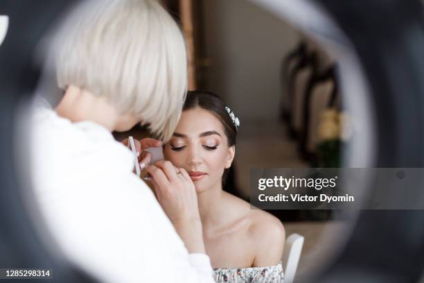 makeup artist prepares bride before the ceremony - bridal makeup stock pictures, royalty-free photos & images