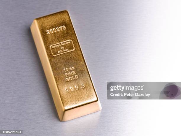 gold ingot with copy space - saving for a rainy day englische redewendung stock-fotos und bilder
