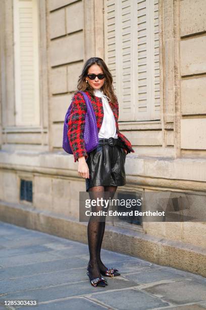 Therese Hellström wears a red checked knitted wool jacket, a white shirt blouse from Tory Burch, black leather shorts from Custommade, pointy colored...