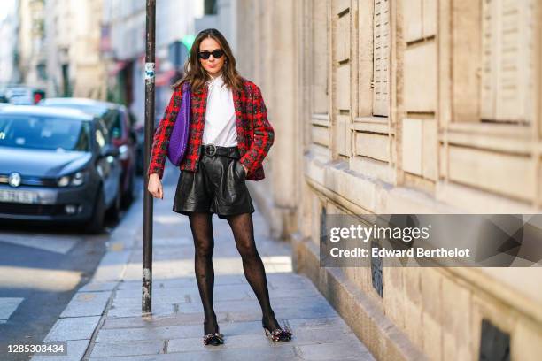 Therese Hellström wears a red checked knitted wool jacket, a white shirt blouse from Tory Burch, black leather shorts from Custommade, pointy colored...