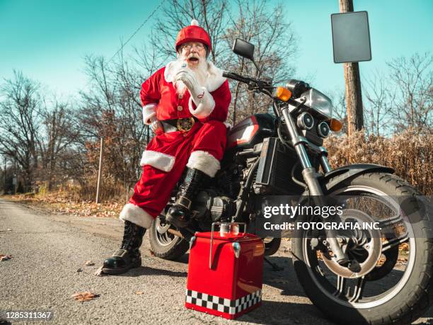 santa claus taking a break on the road - christmas bike stock pictures, royalty-free photos & images