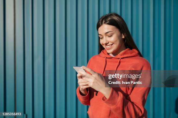 glückliche junge kaukasische frau mit einem smartphone - on a phone cool person stock-fotos und bilder