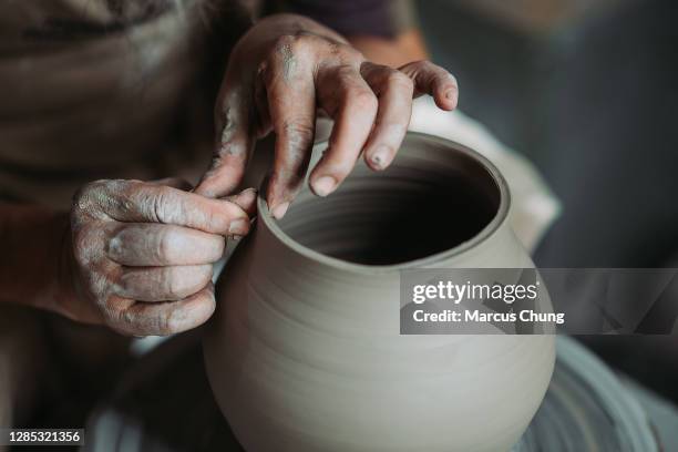 asian chinese senior man clay artist making pottery on a spinning pottery wheel in his craft studio - ceramics stock pictures, royalty-free photos & images