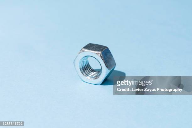 nut on blue background - nut fastener - fotografias e filmes do acervo