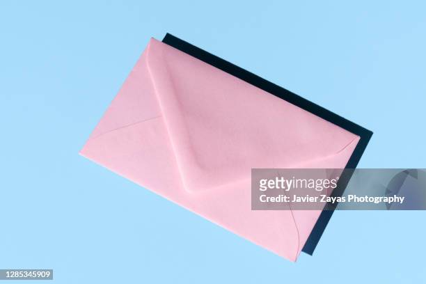 pink envelope on blue colored background - greeting card and envelope stock pictures, royalty-free photos & images