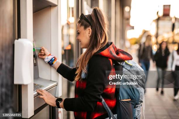 backpacker withdrawing money from atm - stand-alone-atm stock pictures, royalty-free photos & images
