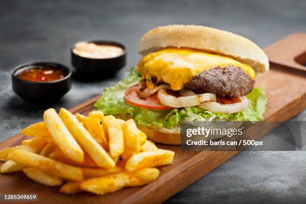 close-up of burger and french fries on table - cheeseburger and fries stock-fotos und bilder