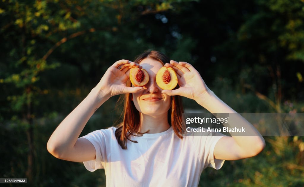 Young cheerful woman relaxing and having fun in summer park, sunny weather.