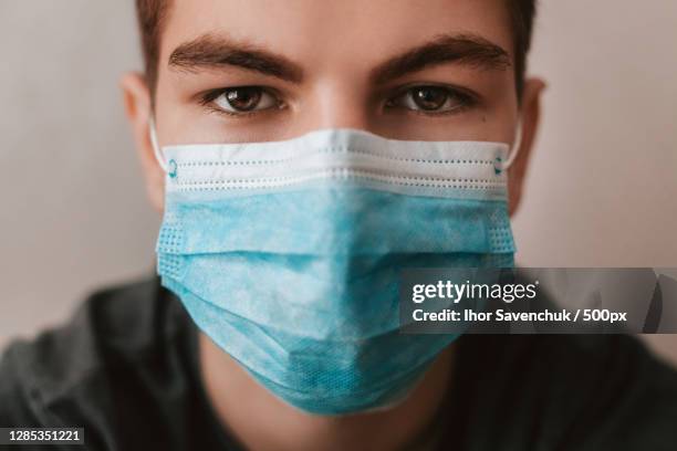 portrait of a young man wearing a medical mask - protective face mask stock pictures, royalty-free photos & images