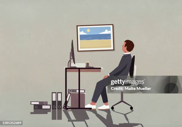 businessman at office desk looking at photograph of beach on wall - eskapismus stock-grafiken, -clipart, -cartoons und -symbole