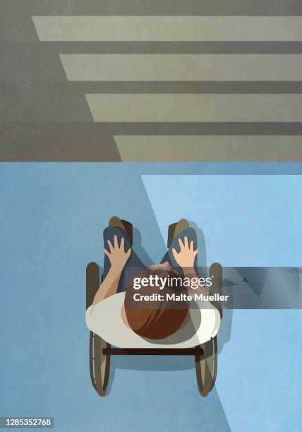 young man in wheelchair at base of staircase - accessibility stock illustrations