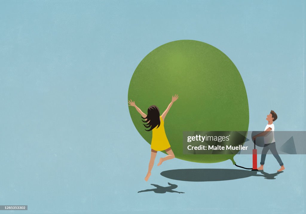 Happy man and woman inflating large balloon