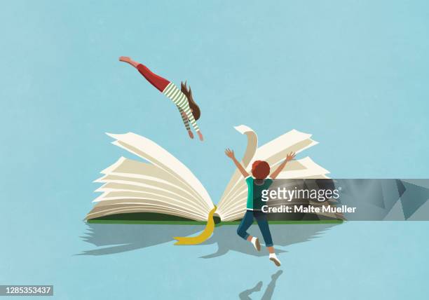 exuberant boy watching girl dive into book - mädchen stock-grafiken, -clipart, -cartoons und -symbole
