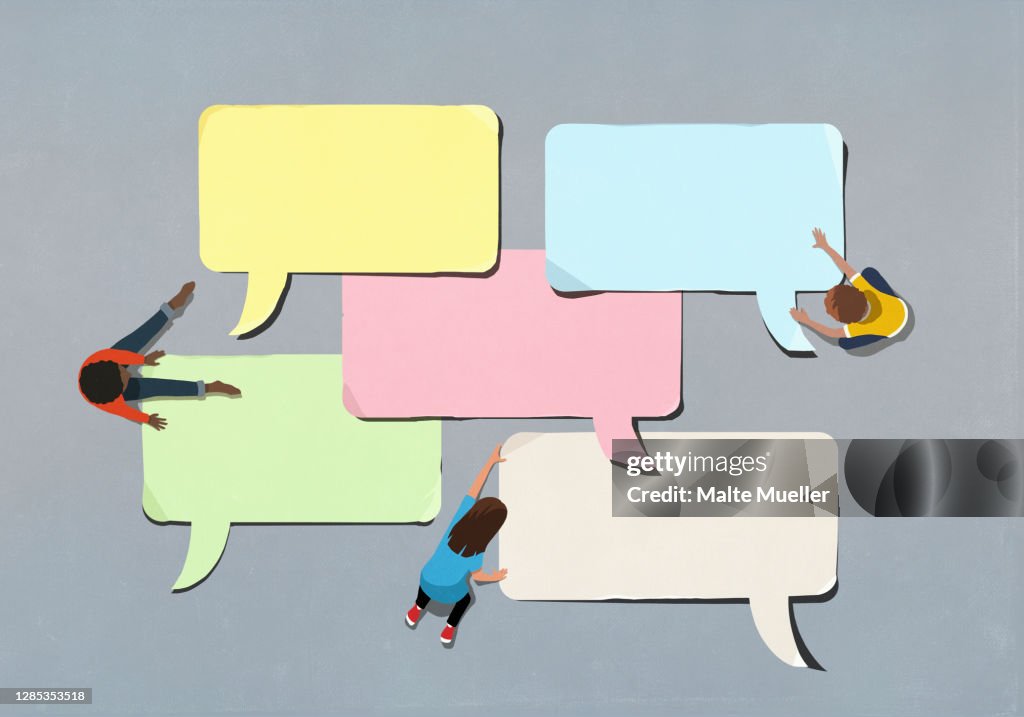 Kids arranging blank multicolor speech bubbles