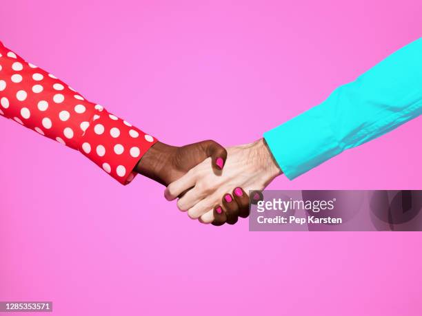 multiethnic handshake on pink background - polka dot shirt stock pictures, royalty-free photos & images