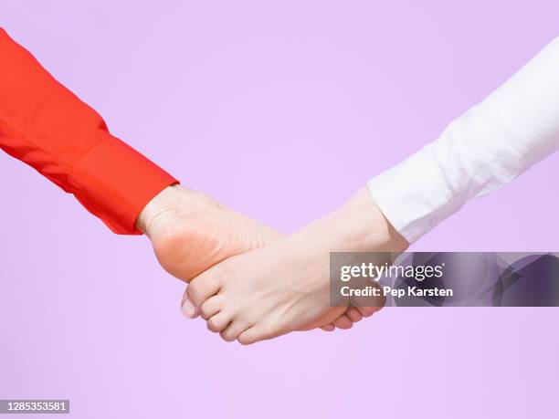 barefoot foot bump on purple background - businesswoman barefoot stock-fotos und bilder