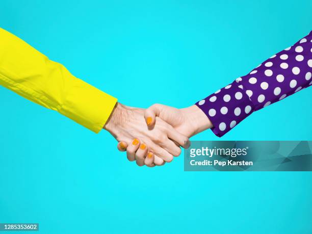 vibrant handshake on turquoise background - top capo di vestiario foto e immagini stock