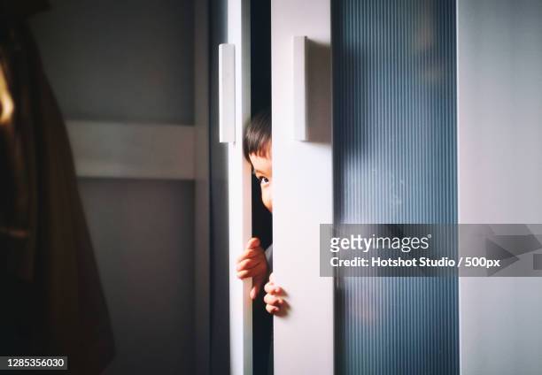 boy peeking out of closet door,singapore - peer bildbanksfoton och bilder