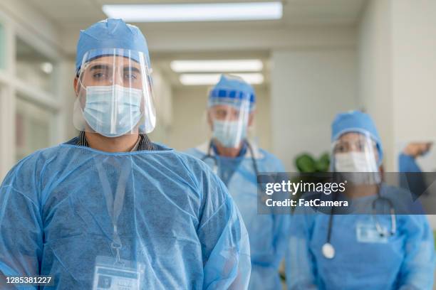 grupo multiétnico de médicos em epi; equipamento de proteção pessoal - enfermeiros - fotografias e filmes do acervo