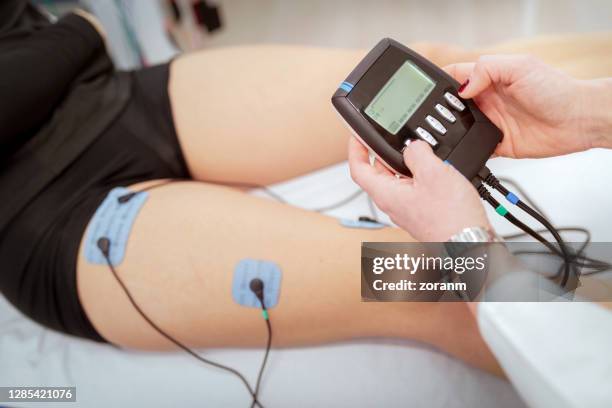 turning on electrostimulation of patient's leg on controlling device - electrode stock pictures, royalty-free photos & images